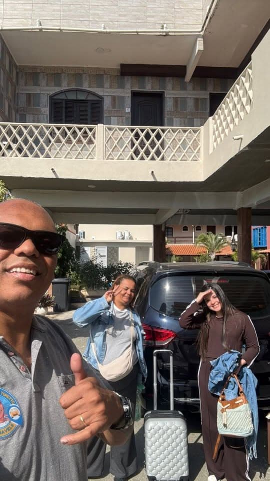 Elton com passageiras e bagagem ao lado do veículo